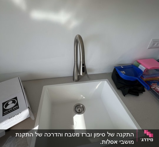 כיור וברז מותקנים על משטח עבודה במטבח